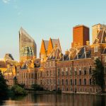 A large building with a lot of windows next to a body of water