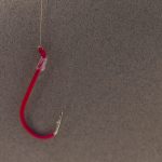 a red fishing hook hanging from a hook
