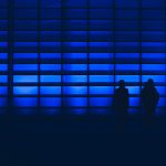 silhouette photo of two person standing near wall